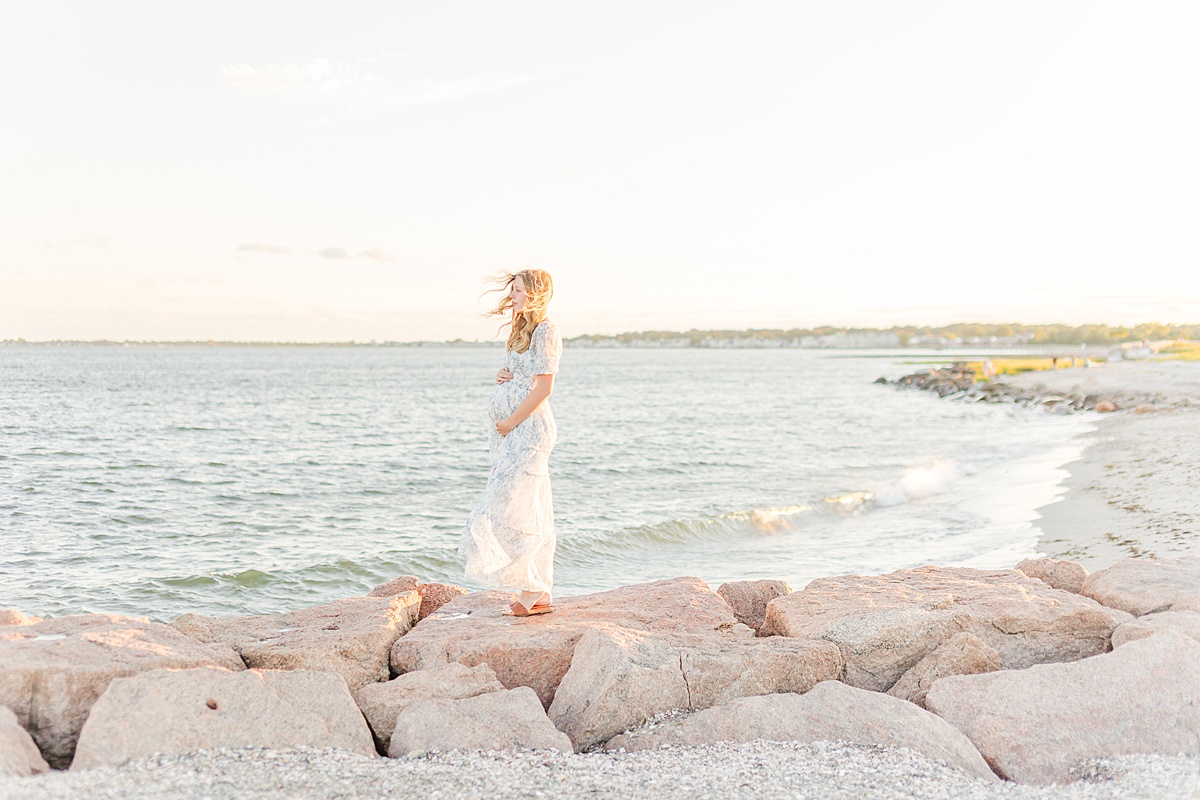 Beautiful beach maternity photo of a mom with wind in her hair