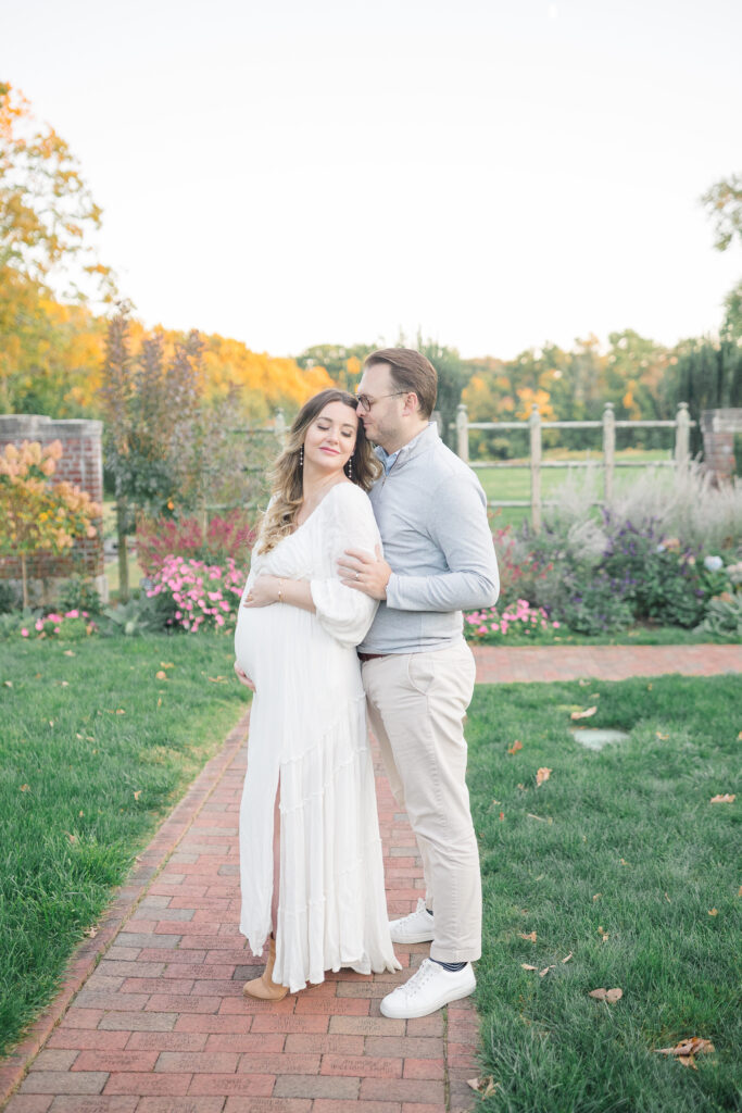 maternity photo at waveny park with flowers in the background