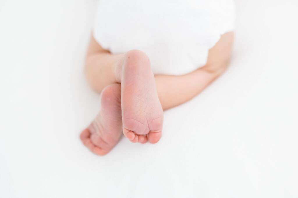 Older sibling holding newborn baby during a newborn photoshoot in Fairfield County CT