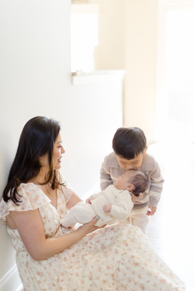 Mother cuddling her newborn during a professional newborn photography session in Fairfield County