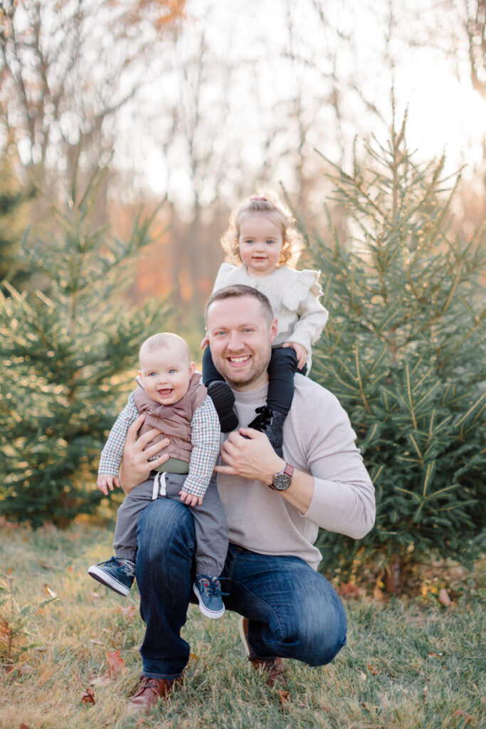 Family wearing cozy neutral outfits for Christmas tree farm photos