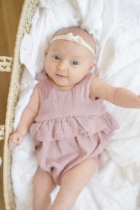 Newborn baby wearing a soft swaddle during a photoshoot in Orange CT