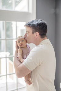 Parents and newborn dressed in coordinated colors for photography in Monroe CT