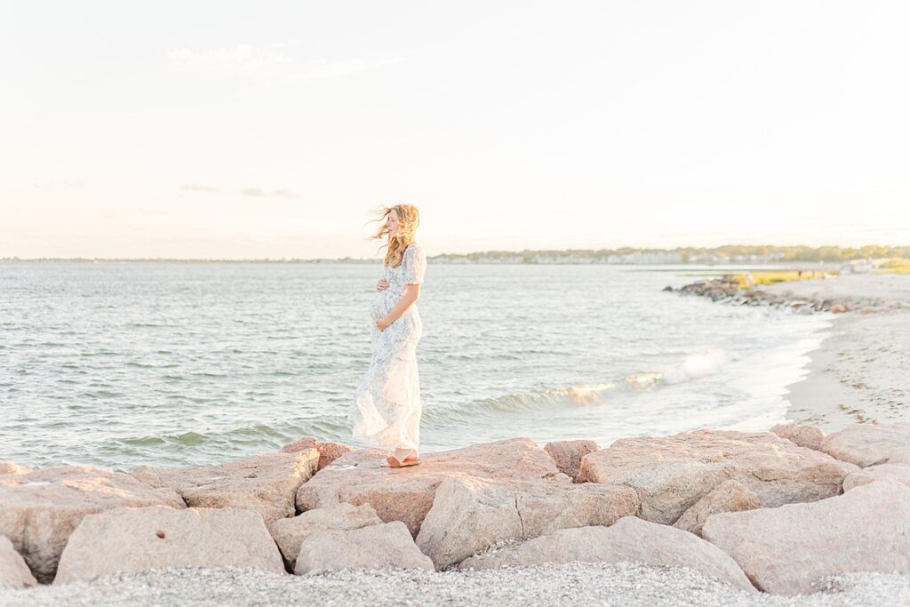 Beautiful beach maternity photo of a mom with wind in her hair