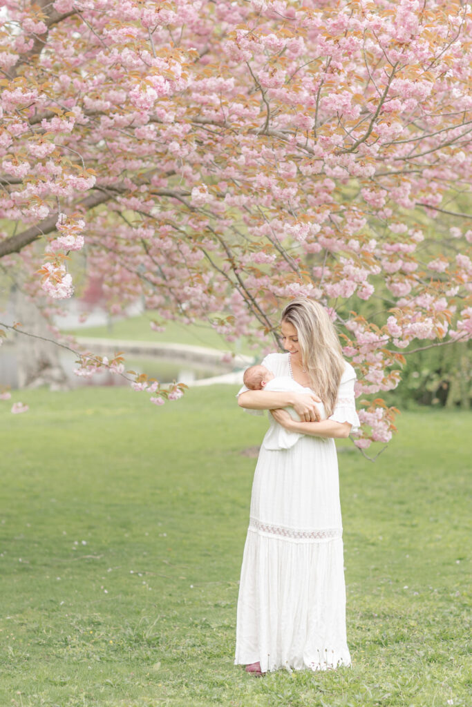 mom and baby in front of blossom tree