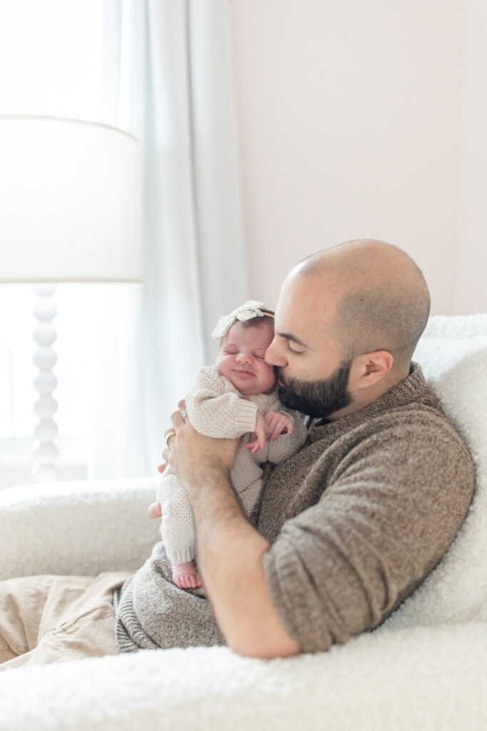 dad snuggling with his newborn baby girl in their home in wilton Connecticut
